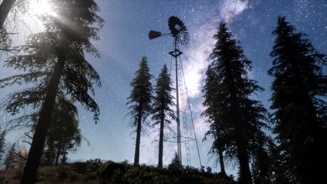retro-windmill-in-mountain-forest-with-stars.-hyperlapse
